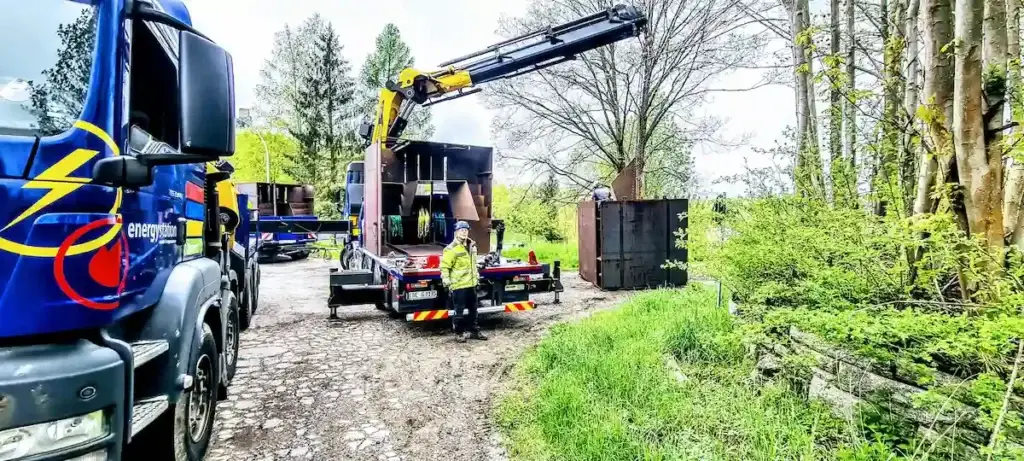 LKW von energystation transportiert einen der 13 massiven Stahlkuben des Kunstprojekts Sichtung durch anspruchsvolles Gelände.